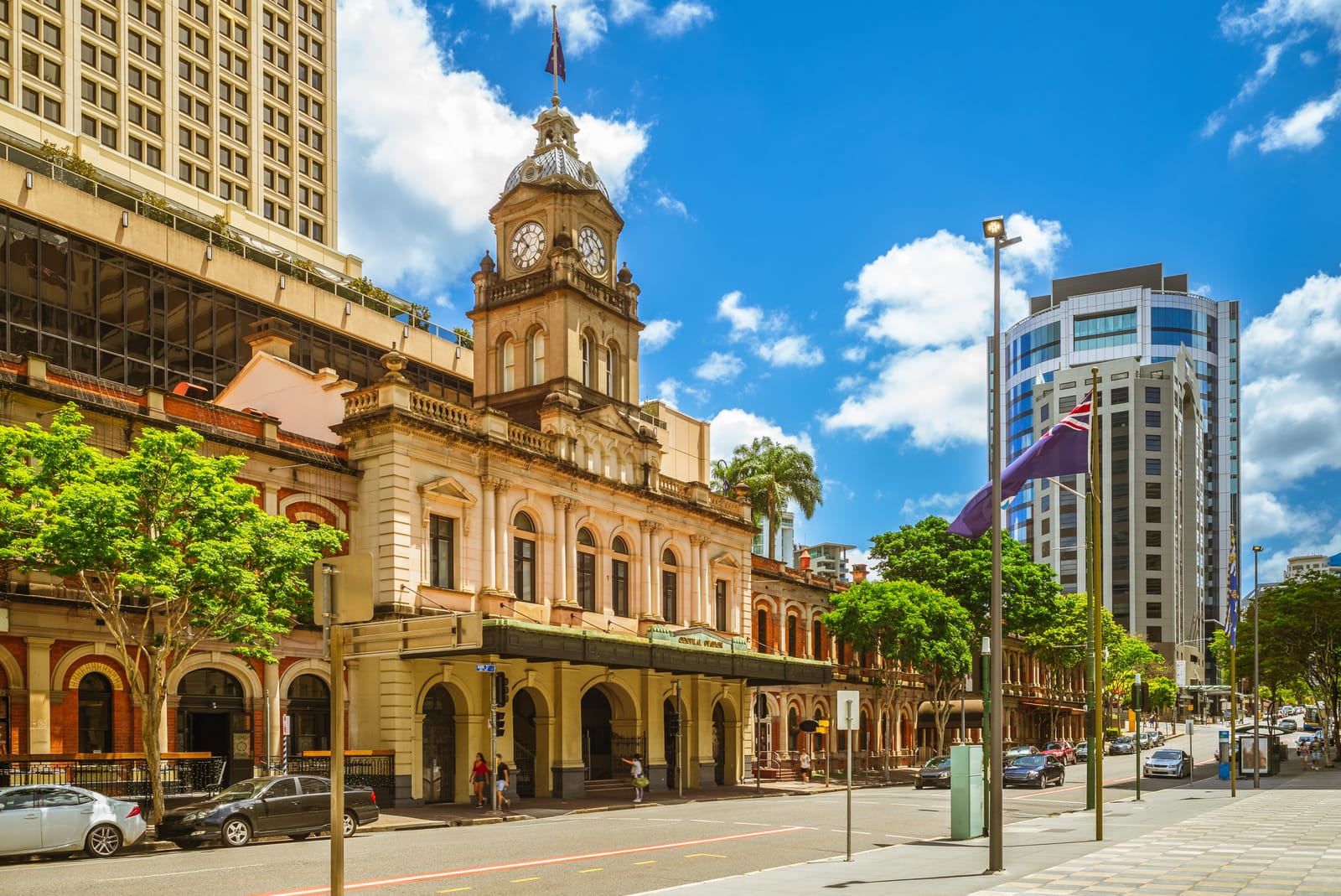 The sandstone clock-tower facade of Brisbane Central Station on Ann Street under a blue sky